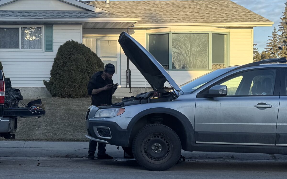 Grayson Mobile Mechanic technician checking under the hood of a customer car on site in Edmonton