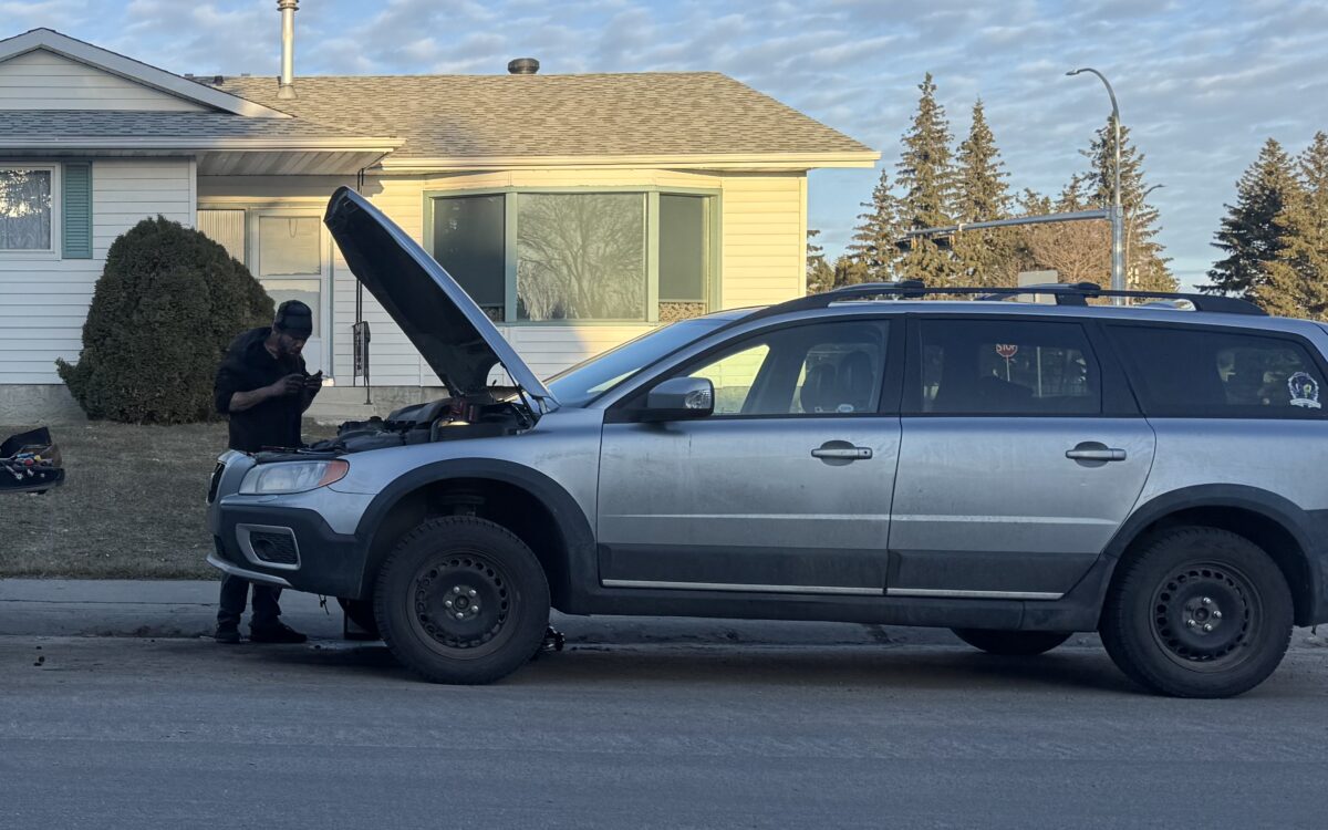Grayson Mobile Mechanic technician working under the hood of a customer car parked on an Edmonton street
